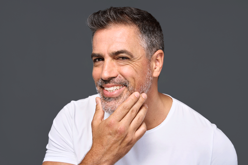 man smiling at his new dental crowns.