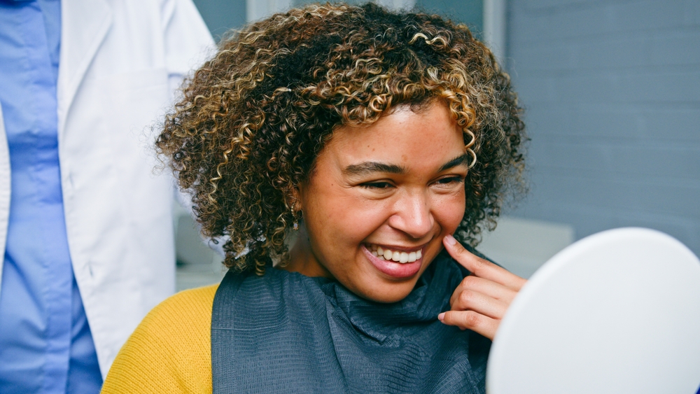 A dentist is using a digital scanner to take impressions of a patient's tooth in preparation for a CEREC crown. The image should evoke a sense of modern technology and patient comfort. No text on image.
